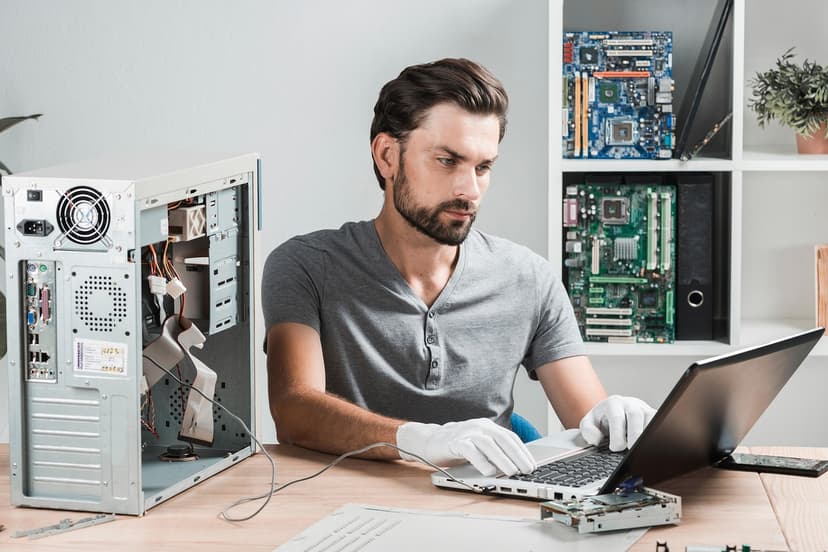 Man working on computer hardware with laptop